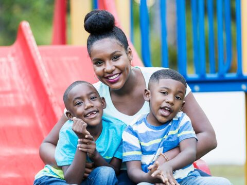 Mother with two sons on a playground slide